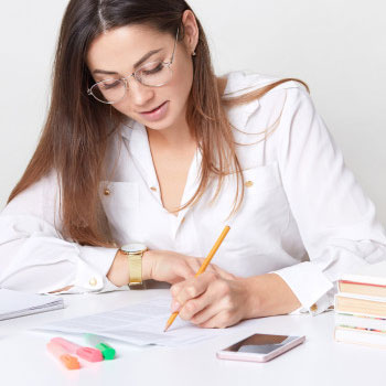 A woman writing on a paper sitting down