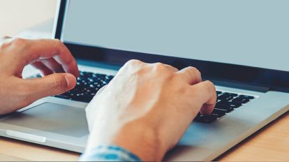 A person typing on his laptop