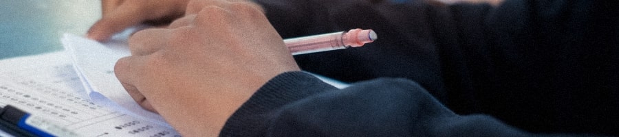 A student holding a pen to answer the examination
