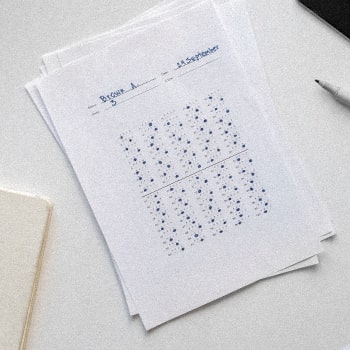 An answer sheet, a document, and a pencil on top of a table