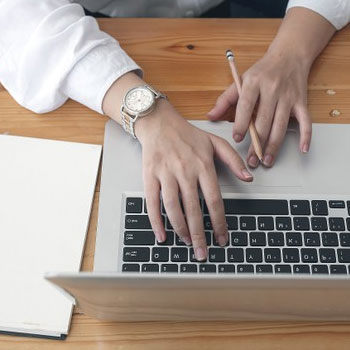 Top view of a woman typing on a laptop