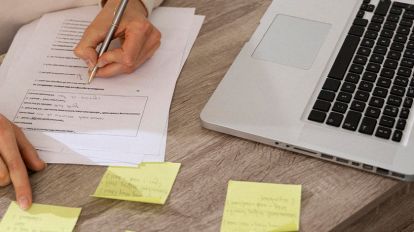 A woman taking tones and busy looking at the sticky notes