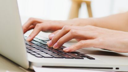 Woman typing on a laptop keyboard
