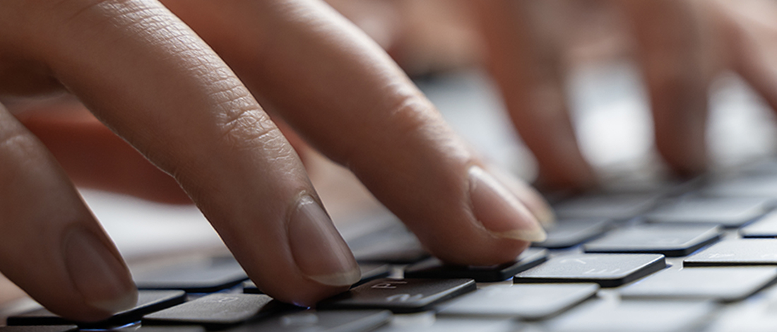 Close up image of a person typing on a laptop