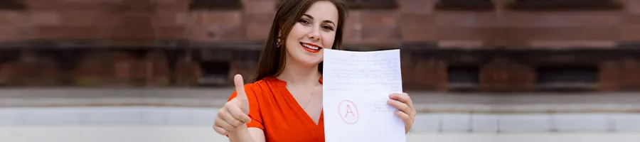 female student holding up her test paper and a thumbs up