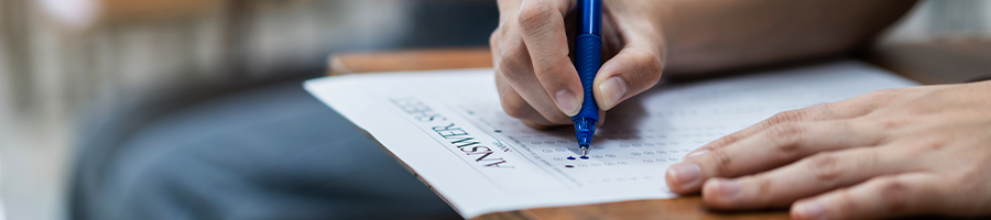 A student answering their answer sheet in an arm chair