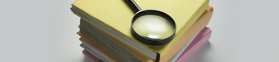 books with magnifying glass